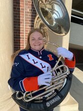 Image of Marie Jensen in Illini Marching Band uniform with large tuba